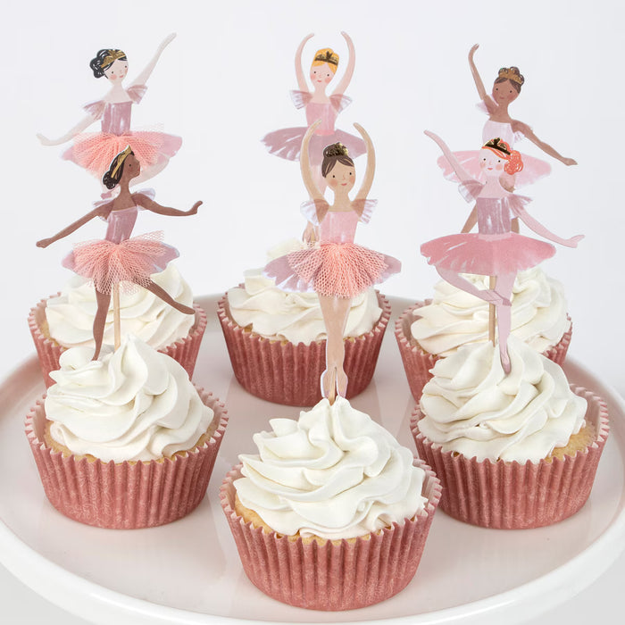 Cupcakes with ballerina toppers on a white plate