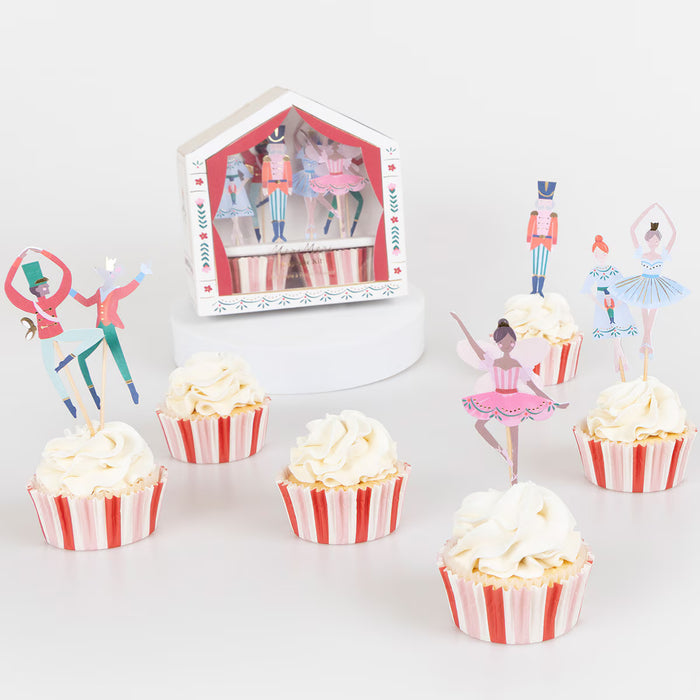 Cupcakes with striped wrappers and ballet-themed toppers on a white background