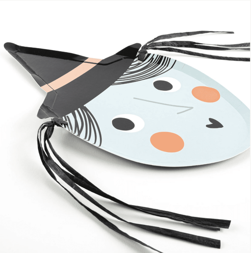 A die-cut paper plate designed to look like a witch's face with a black hat, copper foil detail, and black raffia hair.