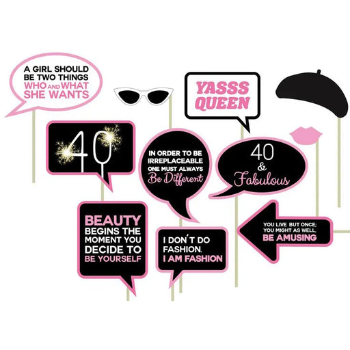 A collection of photo props for a 40th birthday party, including signs with phrases such as '40 & Fabulous' and various other celebratory statements, along with accessories like a beret, sunglasses, and lips.