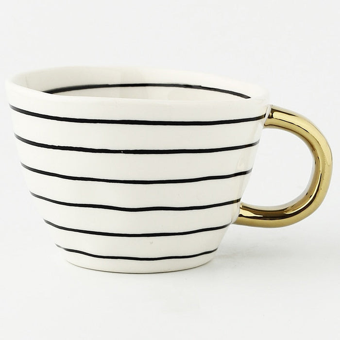 White mug with black stripes and a gold handle on a white background
