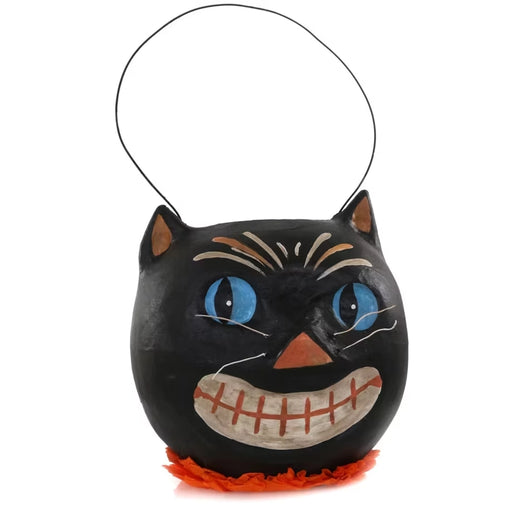 A black cat-shaped Halloween bucket with a thin black handle, featuring blue eyes, a stitched orange smile, and an orange ruffled trim at the base,.