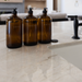 Three amber glass bottles on a kitchen counter with a blurred background