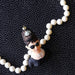 Audrey Hepburn ornament wearing sunglasses and a tiara surrounded by white beads on a black polka dot background.