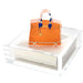 Orange handbag weight on an acrylic napkin holder