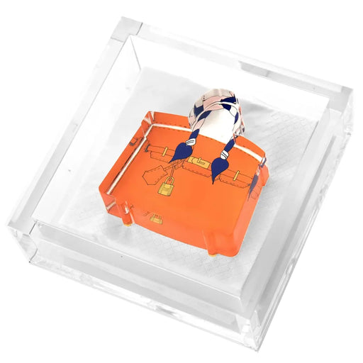 Orange handbag weight on an acrylic napkin holder