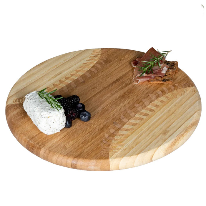 Wooden cutting board with cheese, berries, and cured meat on a white background