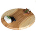 Wooden cutting board with cheese, berries, and cured meat on a white background
