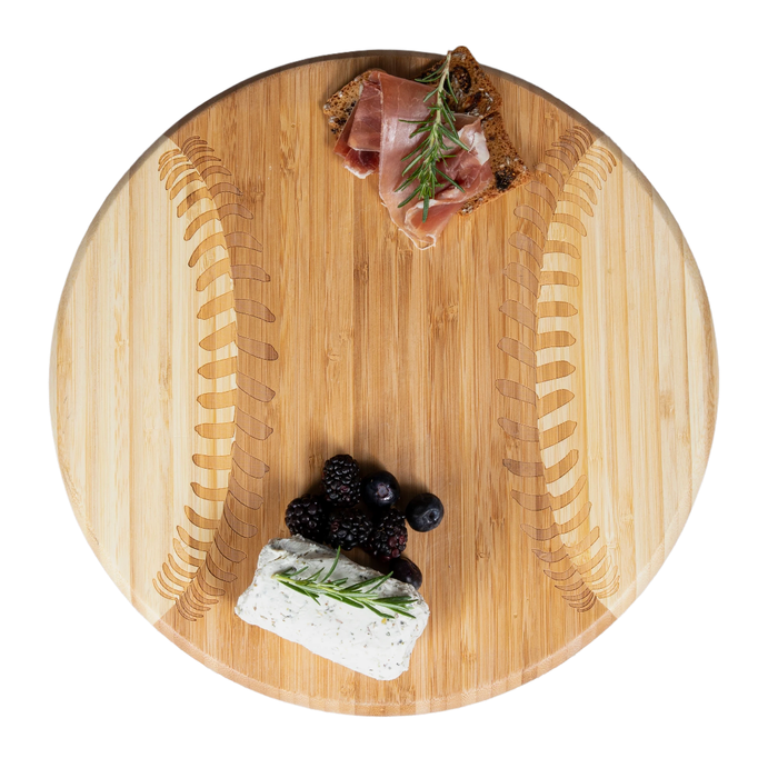 Wooden cutting board with prosciutto, blackberries, and goat cheese on a white background