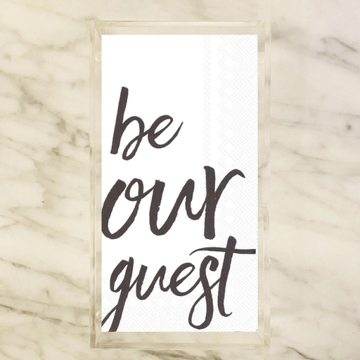 Paper napkins with the saying 'be our guest' text on a marble background