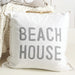 White pillow with 'Beach House' text on a light background