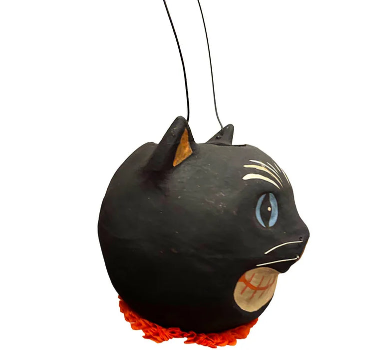 A black cat-shaped paper mâché bucket, hand-painted blue eyes, white whiskers and markings, an orange mouth, and a bright orange ruffled trim at the bottom.