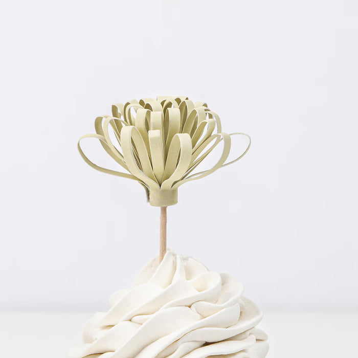 Decorative cake topper shaped like a flower on a white background