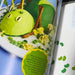 Cakes for kids cookbook. Green caterpillar-themed cake decorated with yellow frosting, pretzel sticks, and green sprinkles. 