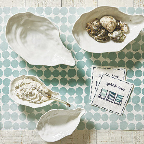 Decorative items including shells, a box with a bow, and a card on a polka dot placemat.