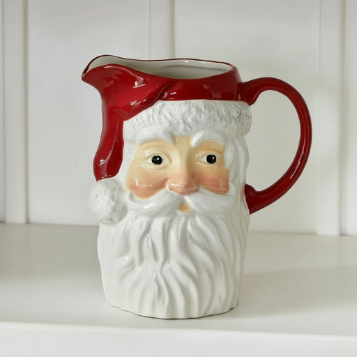 A ceramic Santa Claus pitcher with a red handle and spout.