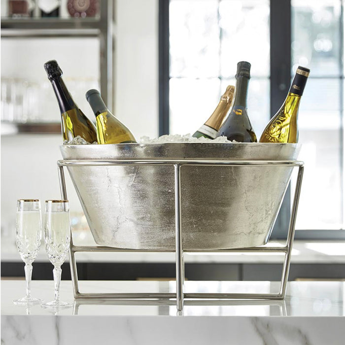 Silver metal ice bucket with champagne bottles on a marble surface