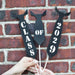Three black paper tie photo props on wooden dowels spelling out "Class of 2029" held against a red brick wall — printable graduation party photo booth props