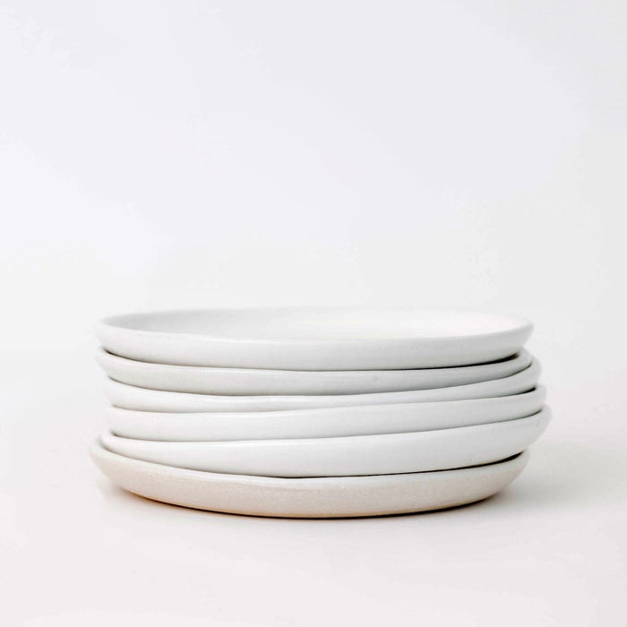 Stack of white ceramic plates on a white background