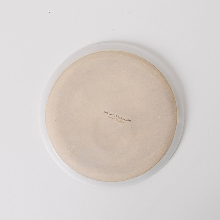 Round beige cushion with a brand logo on a white background