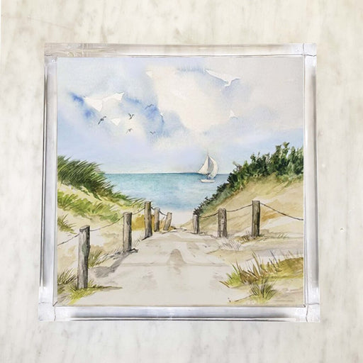 Printed paper napkin featuring a serene dune path leading to the ocean, with a sailboat in the distance and seagulls flying in the sky.