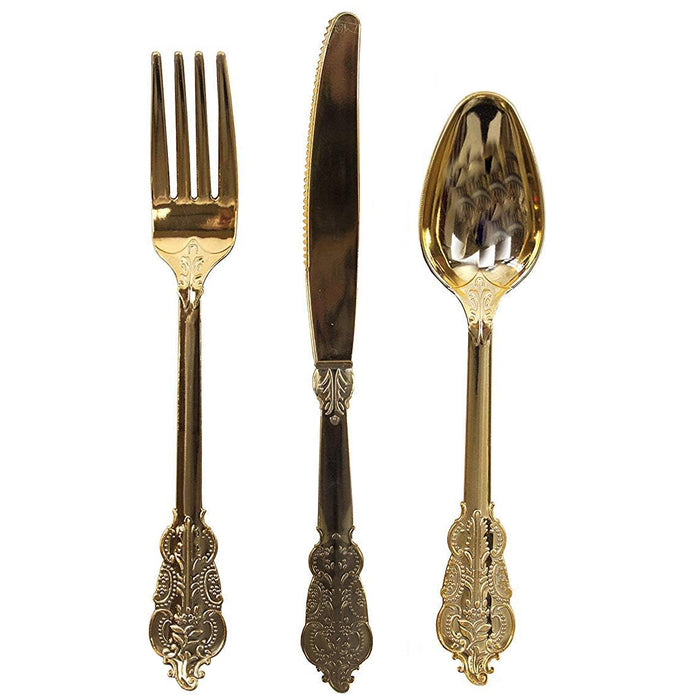 Gold ornate cutlery set with fork, knife, and spoon on a white background