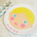 kids personalized melamine plate with a stylized face design and 'Eloise' text on a table setting.