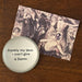 Glass paperweight featuring the iconic quote “Frankly my dear, I don’t give a damn” in black typewriter-style text, placed on a wooden surface beside a vintage-style art postcard of a glamorous ballroom scene.