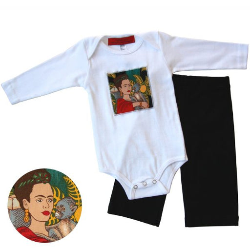 A baby onesie with a Frida Kahlo patch on the front and a pair of black karate pants laid out next to it.