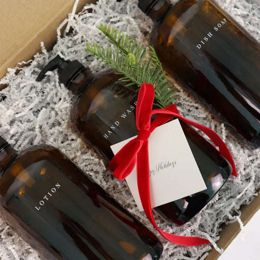 Set of brown bottles with a red bow and gift tag on a textured surface