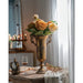 Decorative vase with flowers on a table in a softly lit room
