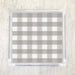 A checkered grey and white patterned paper napkin displayed on a surface.