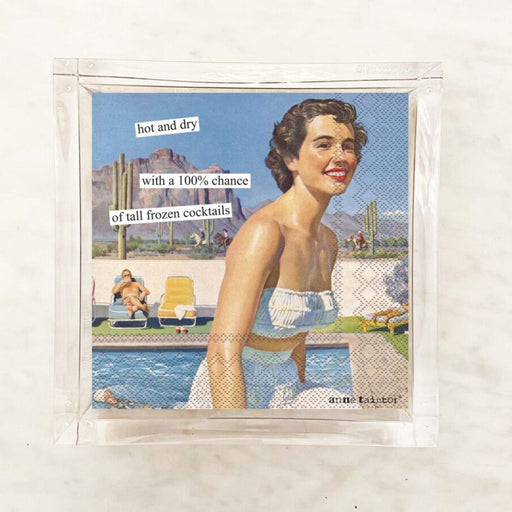 Packaging for Anne Taintor cocktail napkins featuring an illustration of a woman at a poolside with text indicating the napkins are 'hot and dry' with a chance of frozen cocktails.