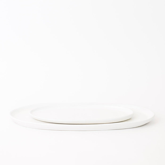 Two white ceramic plates stacked on a white background