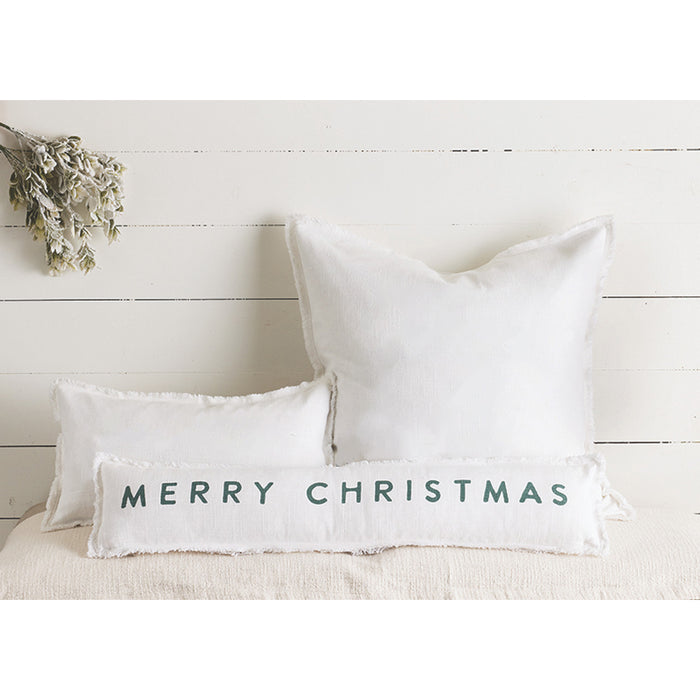 White pillows with 'Merry Christmas' text on a white wooden background