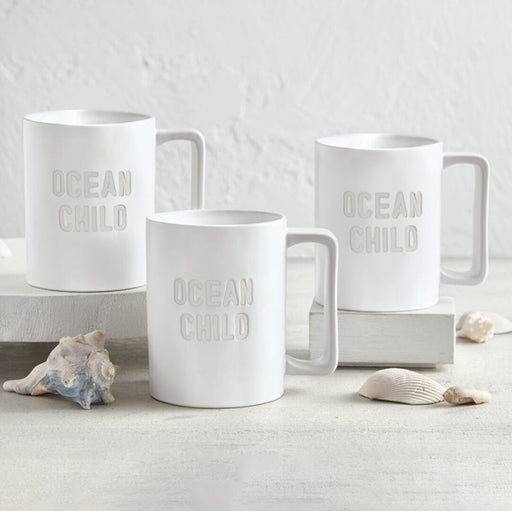 Ocean Child matte white ceramic mug styled on white surface