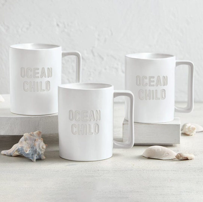 Ocean Child matte white ceramic mug styled on white surface