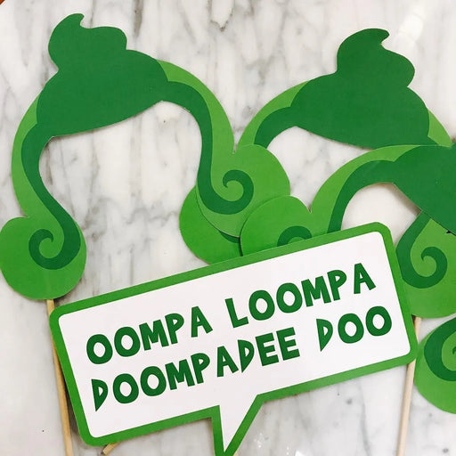 Green Oompa Loompa hair and "Oompa Loompa Doompadee Doo" speech bubble photo booth props on wooden dowels — perfect for Willy Wonka and Charlie and the Chocolate Factory themed parties