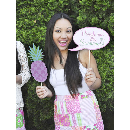 Woman holding printable Palm Beach party props including a pink and green pineapple and a custom speech bubble reading "Pinch me it's Summer"