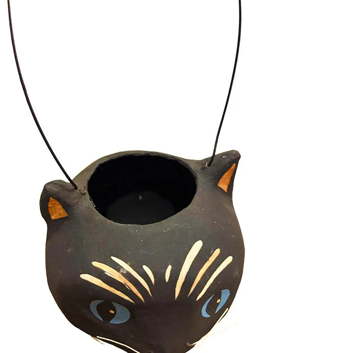 A black cat paper mâché bucket with blue eyes, cream whisker details, and orange inner ears,.