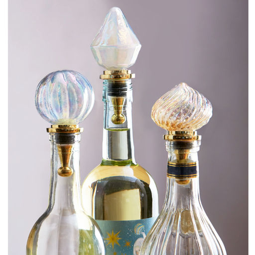 Three decorative bottles with unique stoppers on a gray background