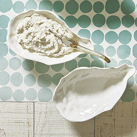 Decorative items including shells, a box with a bow, and a card on a polka dot placemat.
