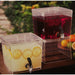 Clear stacking beverage dispensers outdoors filled with lemonade and fruit drink