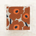 Fabric swatch with orange floral pattern on a beige background