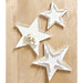 Three white star-shaped decorative items on a wooden surface