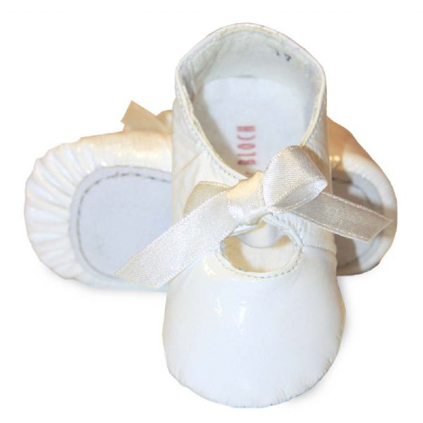 A pair of white patent leather baby ballerina slippers with a bow tie.