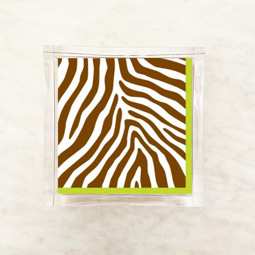 Paper napkin featuring a bold cocoa brown and white zebra stripe pattern with a green border