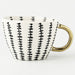 Ceramic mug with black wavy pattern and gold handle on a white background