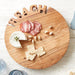 Round acacia wood beach cutting board with carved BEACH lettering styled with cheese and crackers