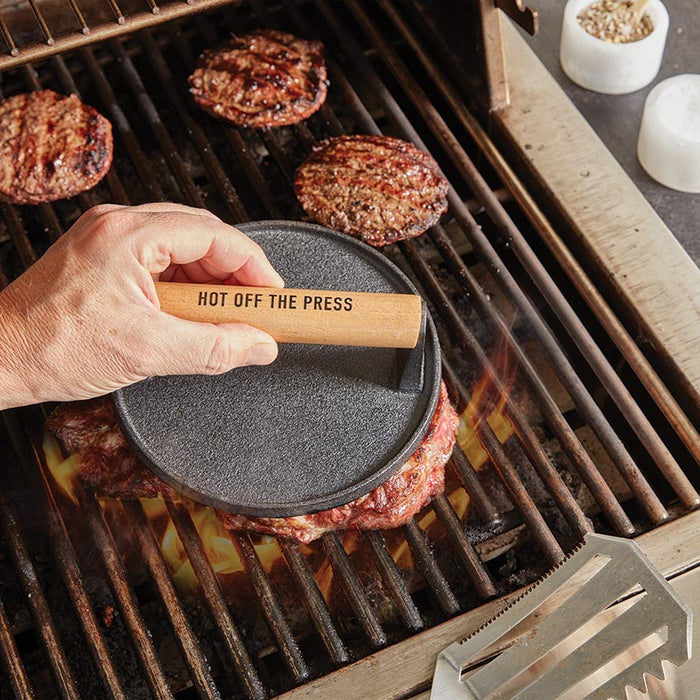Cast Iron Meat Press for Smash Burgers — in use on hot grill pressing smash burgers with Hot Off The Press wood handle